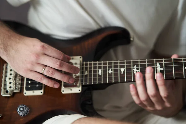 Manos de un músico tocando la guitarra eléctrica de cerca — Foto de Stock