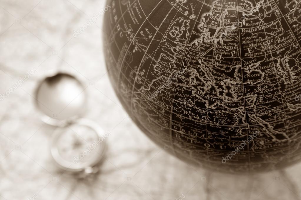 An ancient map of the world with a compass on the backgorund