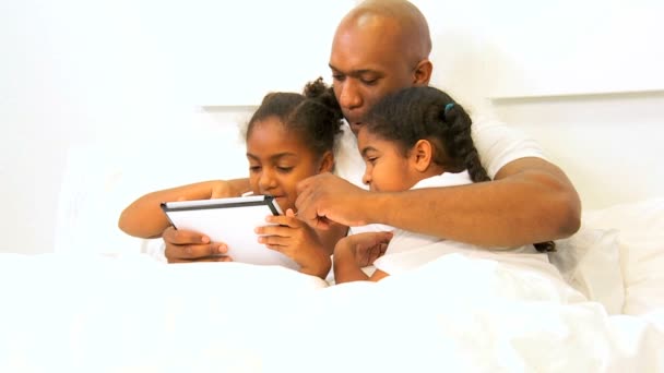 Unga etniska ensamstående pappa barn som använder trådlös tablet säng — Stockvideo