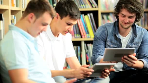 Amigos estudiando tecnología informática en la biblioteca de información — Vídeo de stock