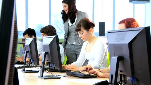 Estudantes trabalhando em computador com professor em hub — Vídeo de Stock