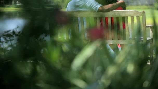 享受湖景高级种族夫妇坐板凳 — 图库视频影像