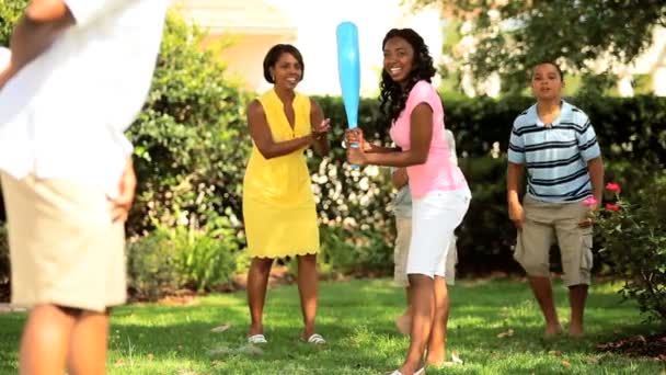 Этническая дочь ловит мяч на игре с семьей — стоковое видео