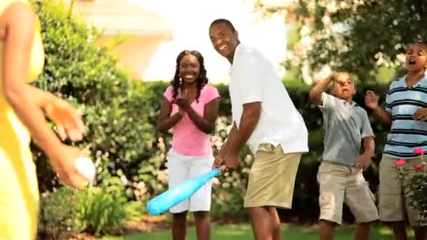 Дружественная бейсбольная игра этнической семьи в саду — стоковое видео