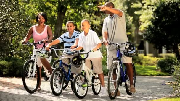 Padres étnicos en bicicleta junto con los niños — Vídeo de stock