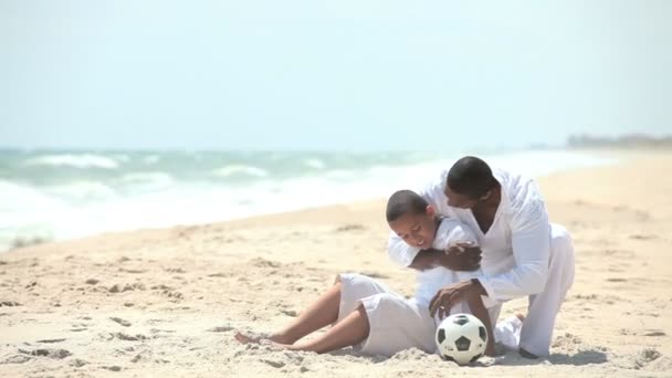 Père diversifié riant avec fils adolescent sur la plage — Video