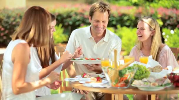 Familia compartiendo almuerzo saludable en el jardín — Vídeo de stock