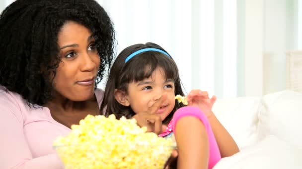 Jonge etnische moeder dochter eten popcorn — Stockvideo