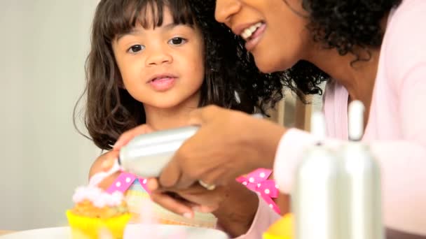 Niedliche kleine ethnische Mädchen Zuckerguss winzigen Kuchen — Stockvideo