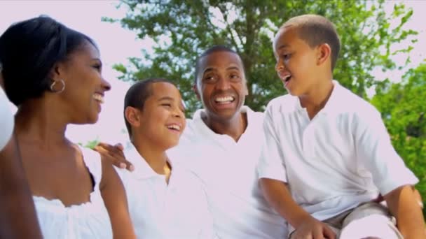Padres étnicos riendo familia al aire libre — Vídeo de stock