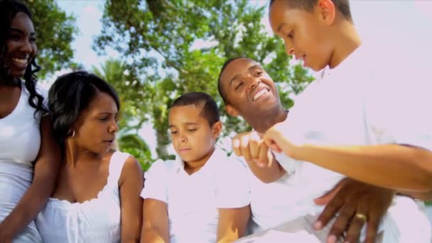 Föräldrar söner tonåriga dotter talar tillsammans trädgård bänk — Stockvideo