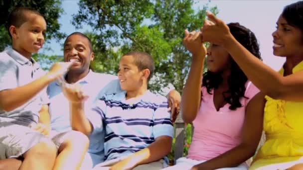 Padres étnicos riendo familia al aire libre — Vídeo de stock