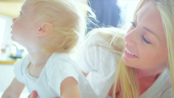 Молоді матері дитини весело в приміщенні — стокове відео