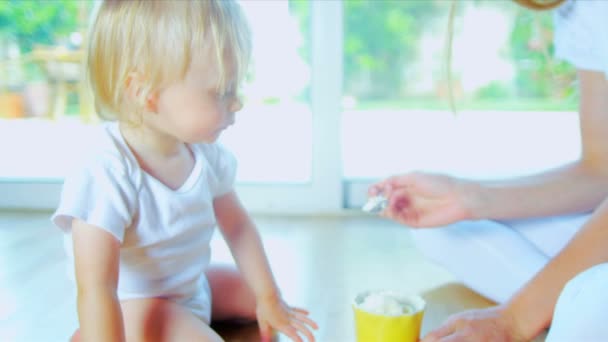Маленького ребенка кормят ложкой — стоковое видео