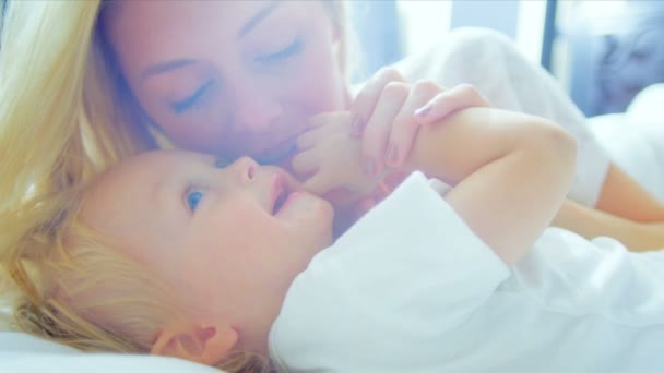 Close-up van blonde mamma bedrijf jong kind slaapkamer — Stockvideo