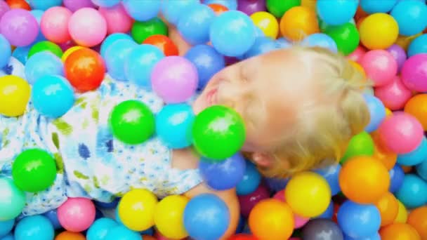 Niño pequeño jugando a la piscina llena de bolas — Vídeos de Stock