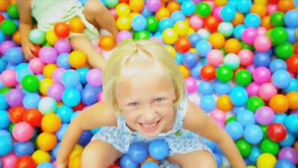 Śmiejąc się mały dziewczyna gry kulki plastikowe — Wideo stockowe