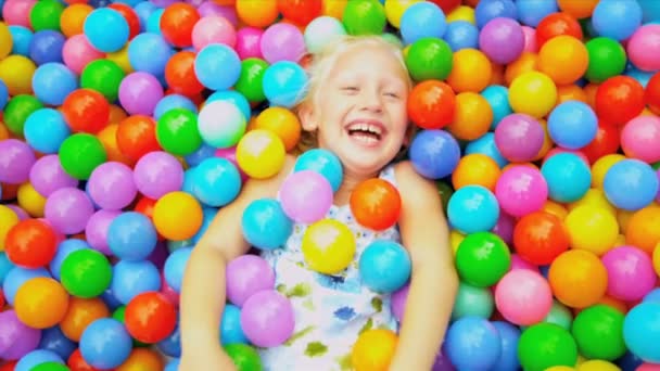 Niño pequeño jugando a la piscina llena de bolas — Vídeo de stock