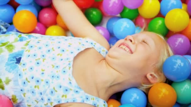 Riéndose niña jugando bolas de plástico — Vídeos de Stock