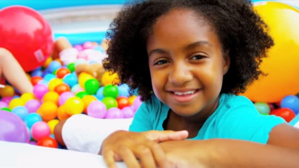 Бассейн, заполненный игровыми мячами для детей разных национальностей — стоковое видео