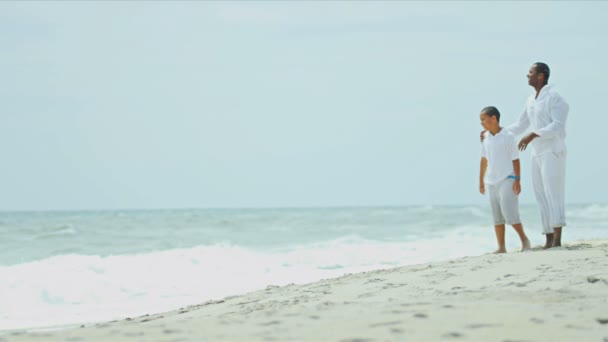 Chłopiec etniczne chodzenia ze sobą ojca kochające, na plaży — Wideo stockowe