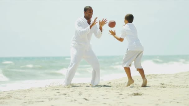 Hijo y padre jugando juntos fútbol americano por el océano — Vídeo de stock