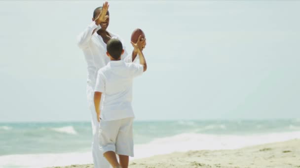 Ethnic parent and son spending vacation playing American football — Stock Video