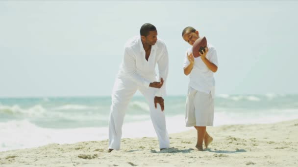 Diverso padre e hijo se divierten jugando fútbol americano en la playa — Vídeo de stock