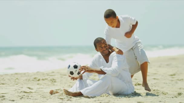 Разнообразные счастливые родители проводят время с ребенком, играя в футбол — стоковое видео