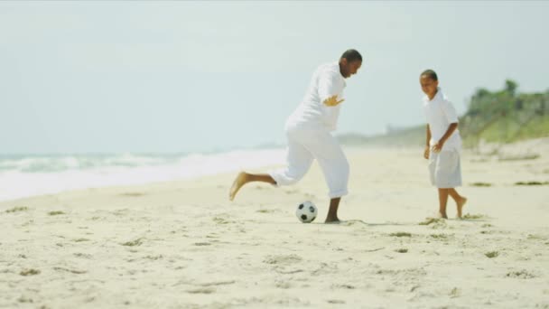 African American boy learning how to play soccer with his father — Stock Video