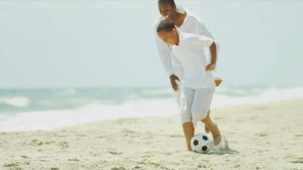 Padres afroamericanos disfrutando del tiempo con su hijo jugando fútbol — Vídeo de stock