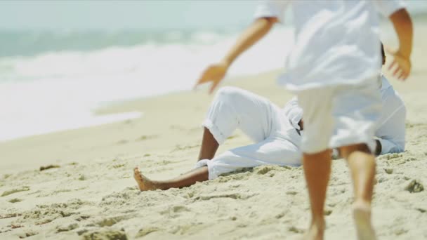 Père ethnique et fils jouant ensemble sur la plage — Video