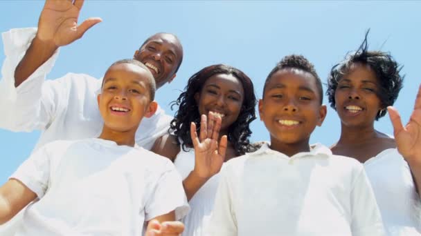 Gros plan de la famille ethnique faisant signe à la caméra sur la plage — Video