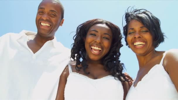 Крупним планом щаслива етнічна сім'я посміхається до камери на пляжі — стокове відео