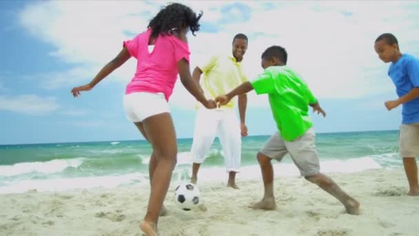 Divers vader samenspelen zonen en dochter voetbal op strand — Stockvideo