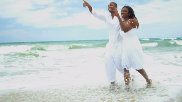 Menina étnica e seu pai se divertem juntos na praia — Vídeo de Stock