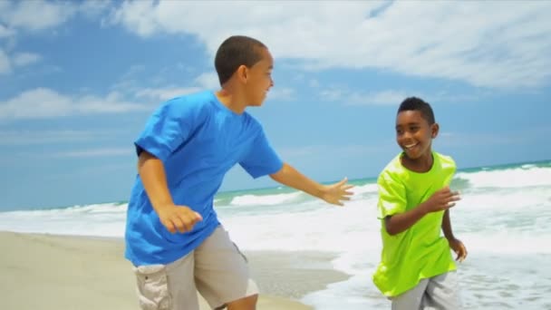 Amigos étnicos felices jugando juntos en la playa — Vídeo de stock