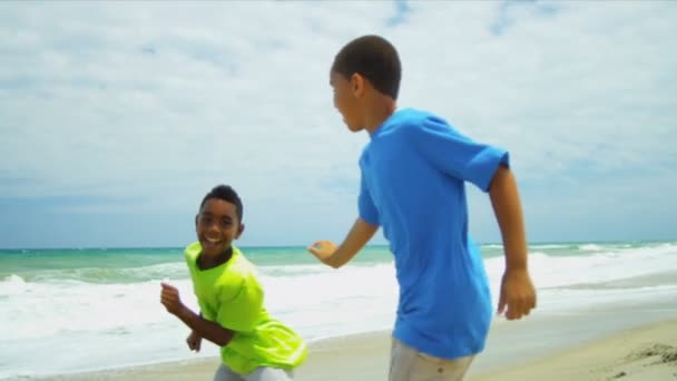 Jeunes frères afro-américains jouant ensemble sur la plage — Video