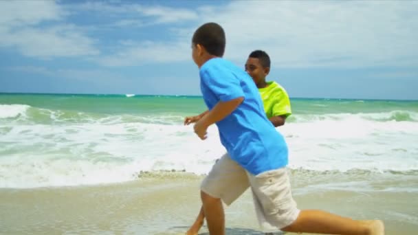 Этнические счастливые друзья, играющие вместе на пляже — стоковое видео