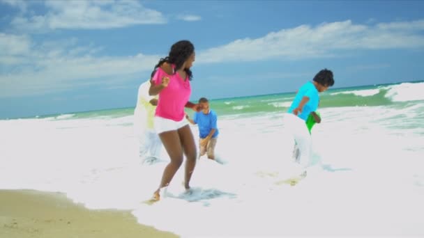 Diverse parents children holding hands having fun together in ocean surfs — Stock Video