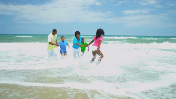 Diverse girl and boys holding parents hands having fun together in ocean surfs — Stock Video