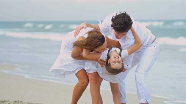 Pais caucasianos abraçando juntos filha na praia de férias — Vídeo de Stock