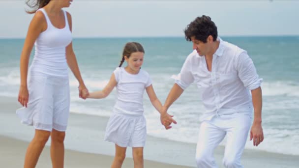 Ragazza caucasica godendo vacanza insieme i genitori vestiti di bianco sulla spiaggia — Video Stock