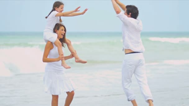 Fille heureuse portée sur les épaules des mères sur la plage père regarder — Video