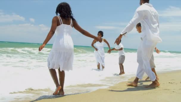 Этнические братья и сестры проводят время с родителями, наслаждаясь пляжем — стоковое видео