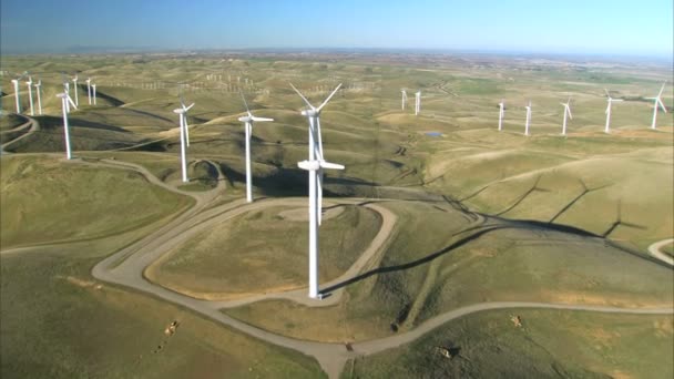 Aerial view of cluster of wind turbines in green hillside — Stock Video
