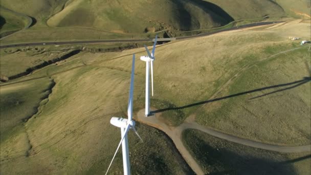 Luftaufnahme einer Ansammlung von Windrädern in grünen Hanglagen — Stockvideo
