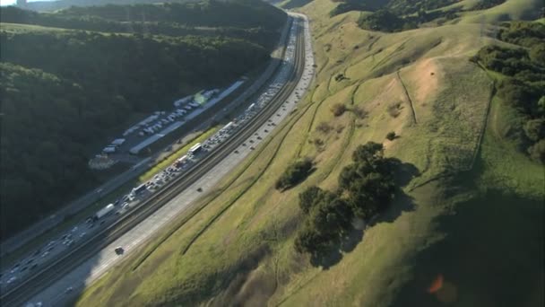 Luftaufnahme des starken Verkehrs auf der viel befahrenen Autobahn in den Hügeln — Stockvideo