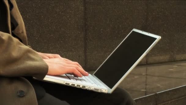 Zakenman op laptop in stad — Stockvideo