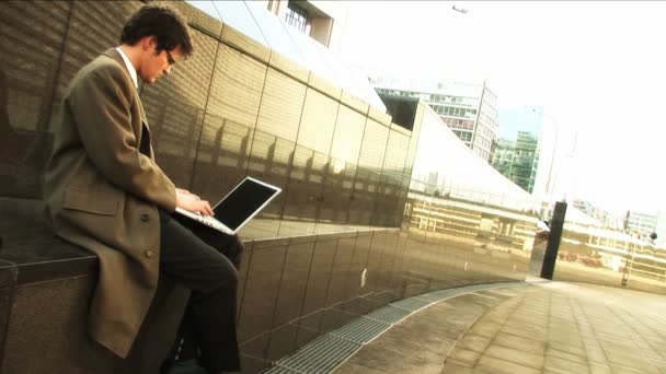 Geschäftsmann am Laptop in der Stadt — Stockvideo